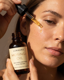 Moringa seed oil bottle with fresh green moringa leaves