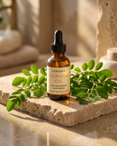 Cold-pressed moringa seed oil bottle on a neutral backdrop